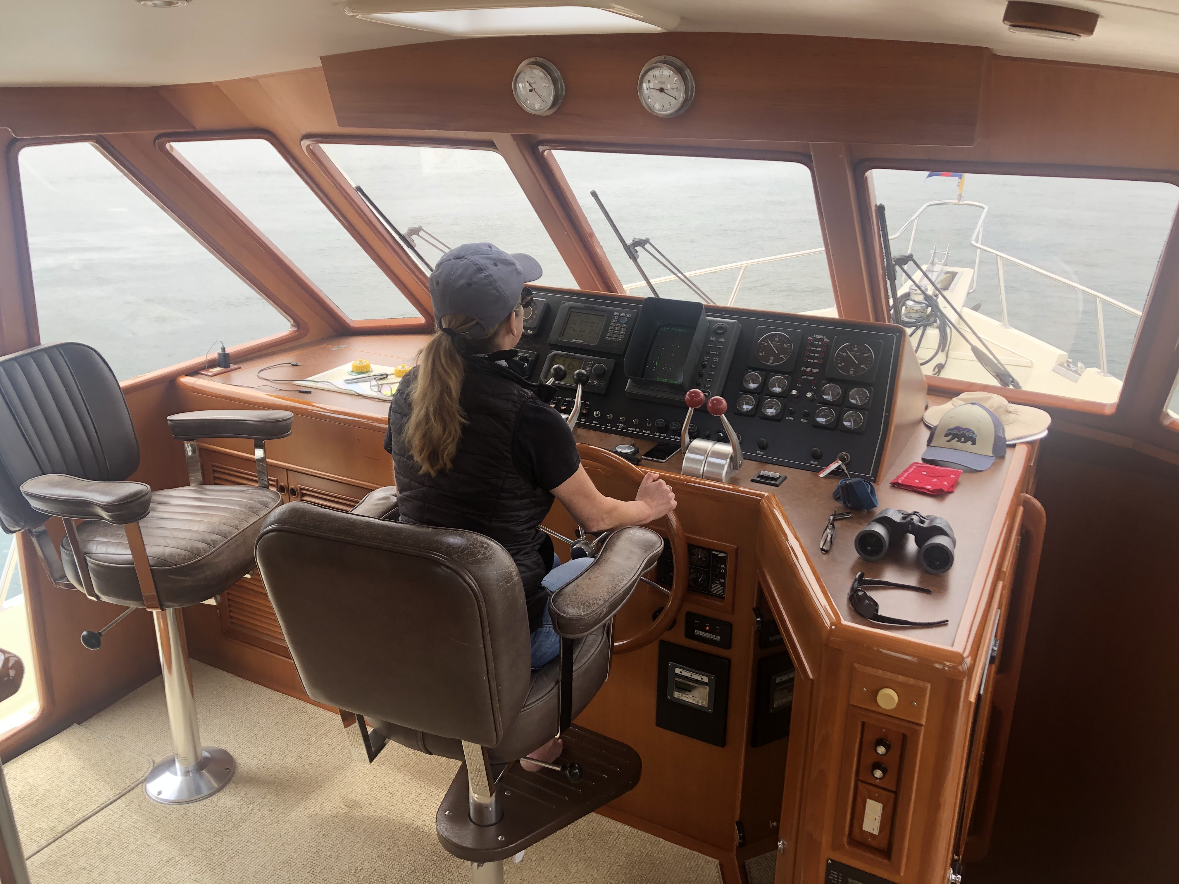 Woman learning to captain a powerboat in the San Diego harbor
