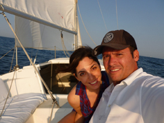 A couple posing for a photo on the deck of a sailboat in San Diego